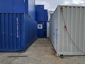 Reihung mehrerer Container von Neubach Container – blaue und hellgraue Container auf Betriebshof mit Stromanschluss